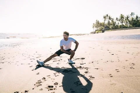 Man exercising on sandy beach Stock Photos