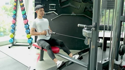 Man Exercising on Seated Cable Row Machine in Gym Stock Footage 325156007
