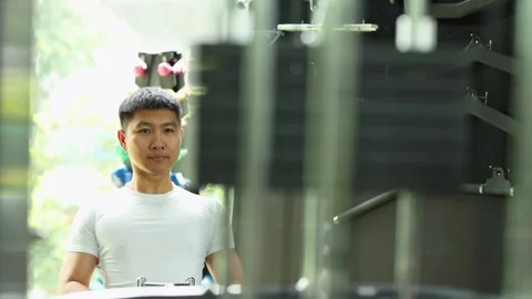 Man Exercising on Seated Cable Row Machine in Gym Stock Footage 326849658