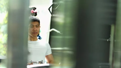 Man Exercising on Seated Cable Row Machine in Gym Stock Footage 328566254