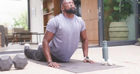 Man exercising in workout clothes, pushing from prone to extended back on patio Stock Footage 341736720