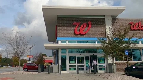 Man exits Walgreens wearing a face mask during covid-19 Stock Footage 142972205