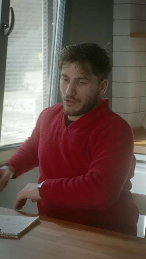 Man Experiencing Back Pain While Sitting in a Cozy Kitchen, vertical video Stock Footage 303681389