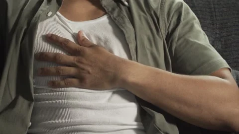 Man experiencing chest pain while sitting on sofa Stock Footage 317056184