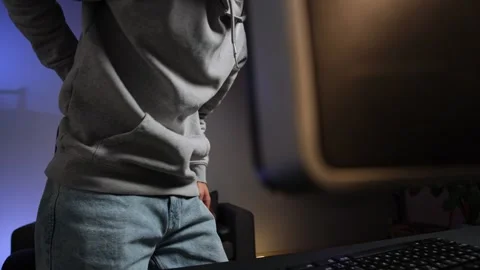 Man experiencing lower back pain at desk during work from home, authentic home Stock Footage 315411483