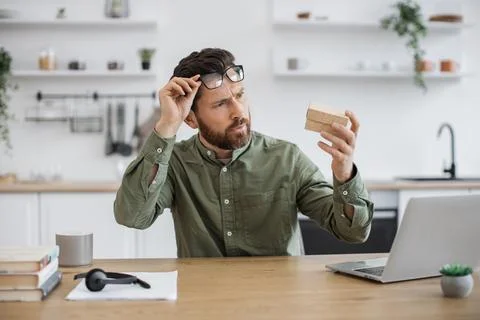 Man experiencing pleasant shock while unpacking parcel box 스톡 사진