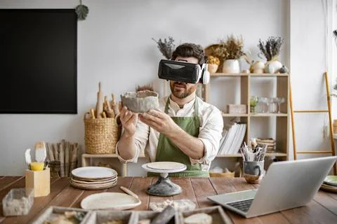 Man experiencing virtual reality technology in pottery workshop Stock Photos