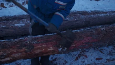 Man expertly debarks logs with an axe in a forest setting Stock Footage 324020668