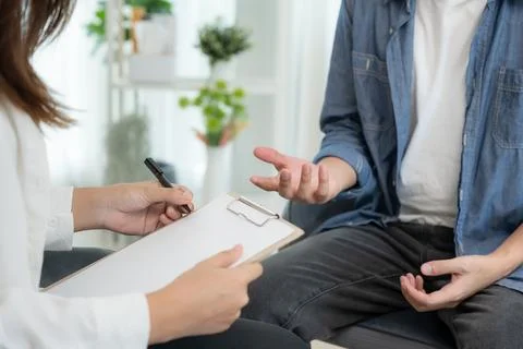 Man explain mental health problems is consulting. psychiatrist is recording.. Stock Photos