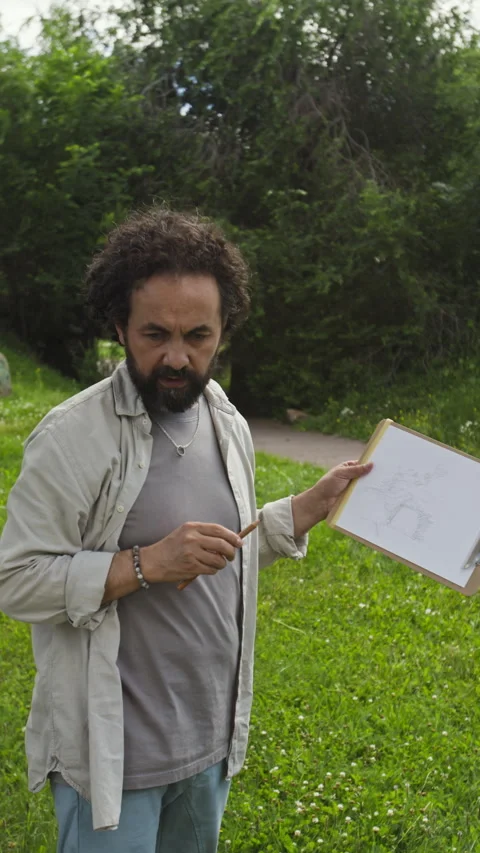 Man Explaining Drawing on Clipboard to Students Outdoors Stock Footage 341955808