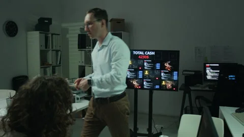 Man Explaining Scam Data on Screen to Female Colleague in Office Stock Footage 346704965