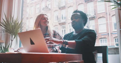 Man explaning something on a laptop to a girlfriend Stock Footage 203583637