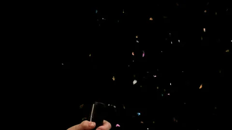 Man explodes a firecracker with shiny confetti footages Alpha Channel Stock Footage 312591542