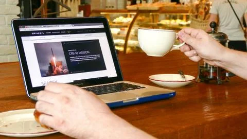 Man explore Space X website on laptop screen in cafe Stock Photos