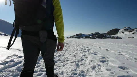 Man explorer walking in the snow on a sunny winter day Stock Footage 175887451