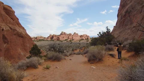 A man explores the desert and takes photos of the Arches National Park, US Stock Footage 287725121