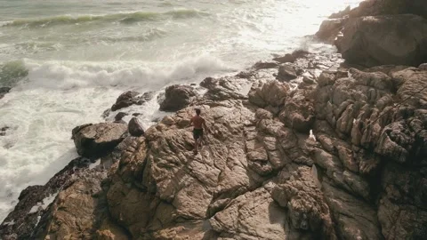 Man explores tropical tide pools at sunset Stock Footage 166388242