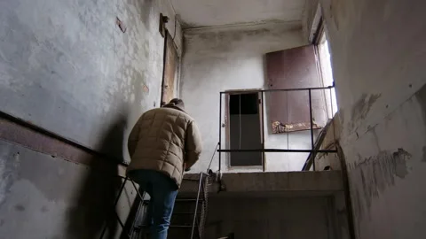 Man exploring an abandoned building in Pripyat, Chernobyl Stock Footage 332829422