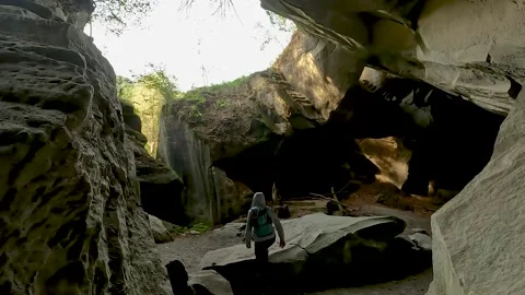 Man exploring an ancient cave Stock Footage 214872975