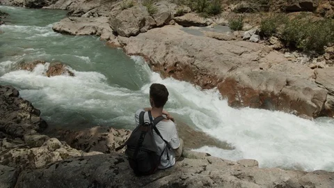 Man exploring the banks of the river in the granite canyon Stock Footage 112734027