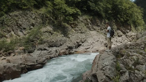 Man exploring the banks of the river in the granite canyon Stock Footage 112734092
