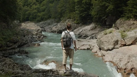Man exploring the banks of the river in the granite canyon Stock Footage 112734125