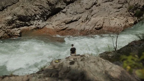 Man exploring the banks of the river in the granite canyon Stock Footage 112734250