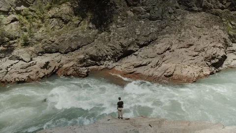 Man exploring the banks of the river in the granite canyon Stock Footage 112734332