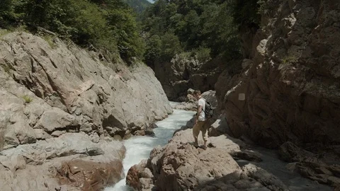 Man exploring the banks of the river in the granite canyon Stock Footage 112734405
