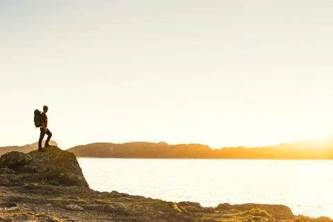 Man exploring the coast line at sunset Stock Photos