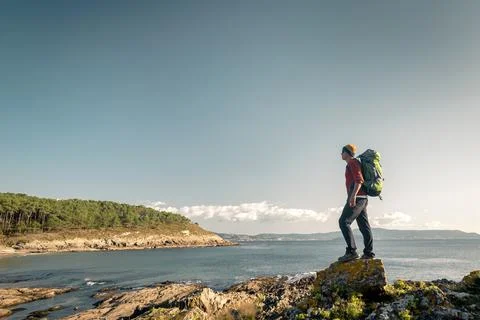 Man exploring the coastline with backpack Stock Photos