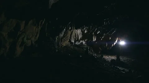 Man exploring deep cave with flashlight Video stock 23773934