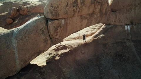 Man Exploring Natural Rock Arch in African Desert Stock Footage 301368696