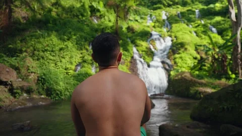 Man Exploring Pelisan Waterfall, Walking Multi-Tiered Rocky River in Bali Видео 347792526