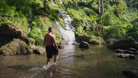 Man Exploring Pelisan Waterfall, Walking Multi-Tiered Rocky River in Bali Stock-Footage 347793410