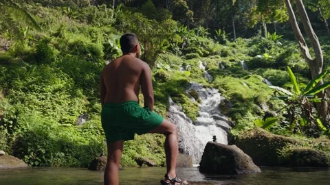 Man Exploring Pelisan Waterfall, Walking Multi-Tiered Rocky River in Bali Stock-Footage 347793852
