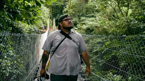 Man exploring rainforest on hanging bridge in Costa Rica Stock Photos