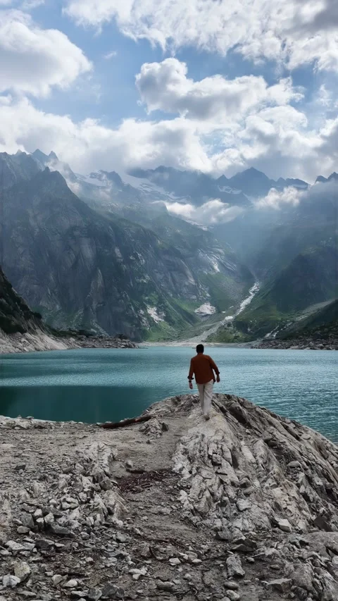 Man exploring a stunning alpine lake in the mountains Stock Footage 318197489