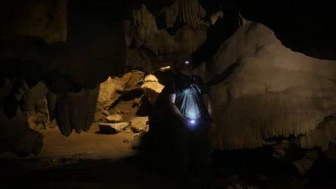 Man exploring Thai Cave with Flashlight Stock Footage 104125774