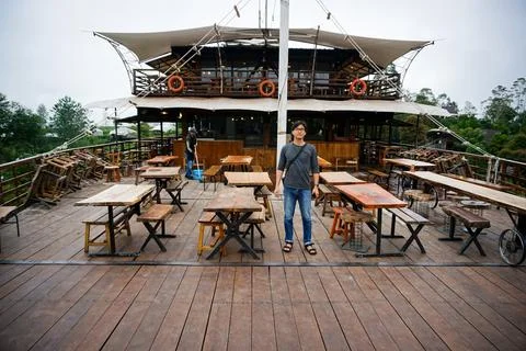 Man Exploring a Unique Ship Themed Restaurant with Wooden Deck in Forest Stock Photos