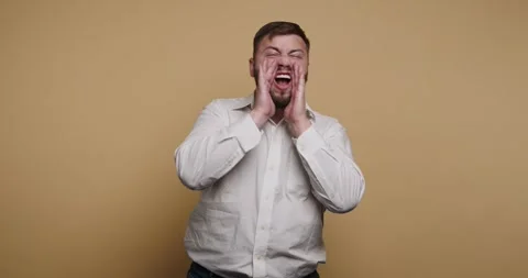 Man expresses strong emotions in front of neutral background during quiet m.. 動画素材 326797360