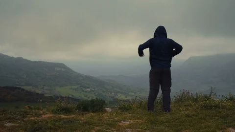 A man expressing freedom on top of a mountain Stock Footage 88719360