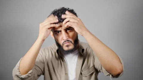 Man expressing various emotions, touching his face and hair Stock Footage 314785345