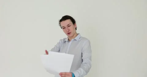Man with expression reads script on white background Stock Footage 290844228