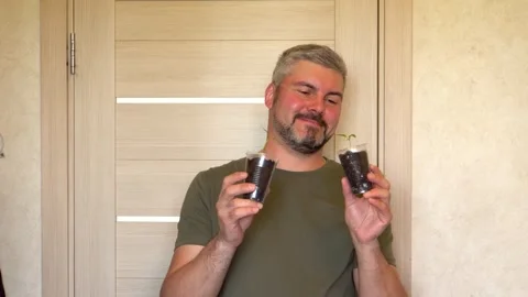 A man extends his hand with a seedling 4K Stock-Footage 274402596
