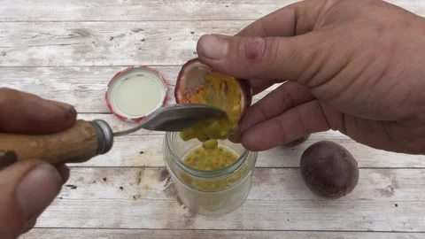Man extracting passion fruit seeds into a glass for planting and propagation Stock Footage 336376912