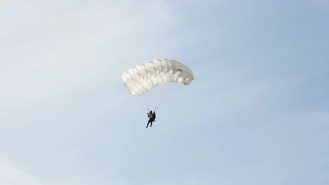 Man extremely descends with a parachute to the ground. Parachute flight Stock Footage 90361504