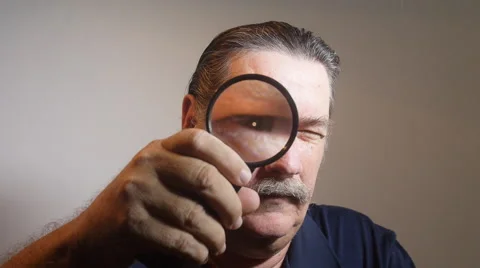 MAN EYE looking through magnifying reading glass Stock Footage 54001947