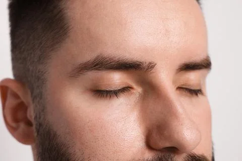 Man before eyebrows correction on light background, closeup Stock Photos