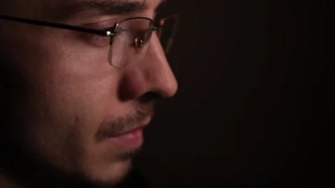 Man in eyeglasses late at night Coder, programmer or developer using laptop in Video stock 146450437
